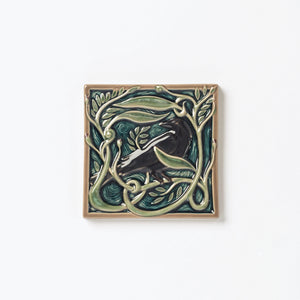 Decorative ceramic tile with Rook or Crow in center surrounded by leaves.