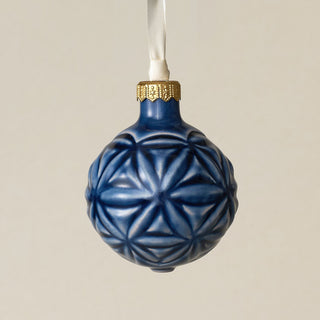 Intricately carved and glazed ceramic globe ornament with ivory satin ribbon –