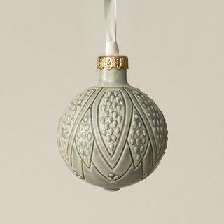 Intricately carved and glazed ceramic globe ornament with ivory satin ribbon –