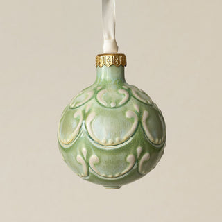 Intricately carved and glazed ceramic globe ornament with ivory satin ribbon –