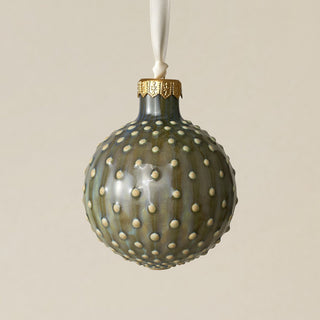 Intricately carved and glazed ceramic globe ornament with ivory satin ribbon –