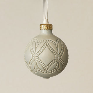 Intricately carved and glazed ceramic globe ornament with ivory satin ribbon –