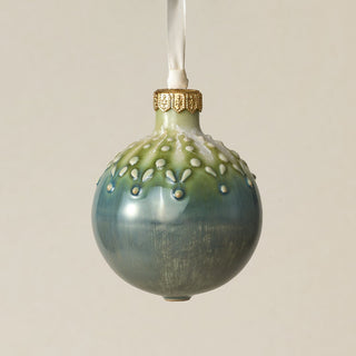 Intricately carved and glazed ceramic globe ornament with ivory satin ribbon –