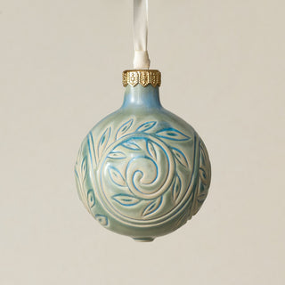 Intricately carved and glazed ceramic globe ornament with ivory satin ribbon –