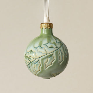 Intricately carved and glazed ceramic globe ornament with ivory satin ribbon –