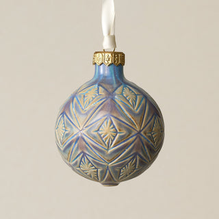 Intricately carved and glazed ceramic globe ornament with ivory satin ribbon –