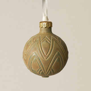 Intricately carved and glazed ceramic globe ornament with ivory satin ribbon –