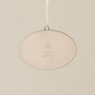 Backside of the Rookwood Queen City ornament in Sencha glaze: oval light beige ceramic with an embossed RP logo, item number, and 'MMXXVI' in the center, suspended by a white ribbon against a textured beige background.
