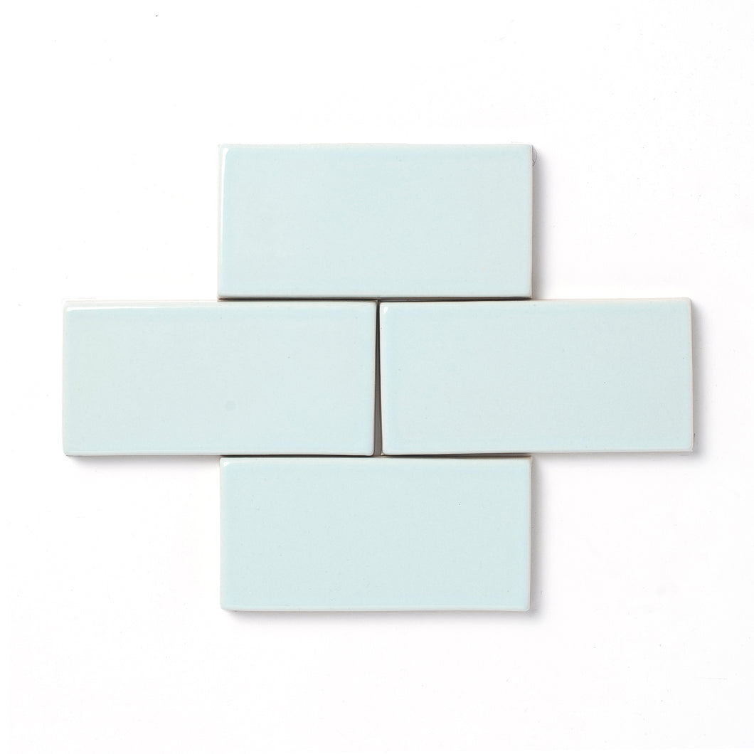 Inspired by the Alpine mountaintops, this cool neutral glaze presents a slight variation in color and features a hint of powder blue, reflective high gloss surface, and typically opaque break along relief details and tile edges.