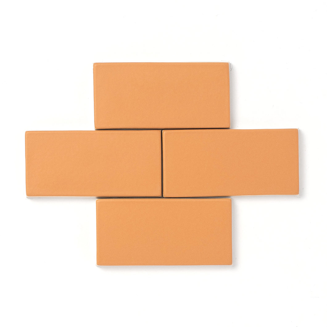 This smooth matte glaze features a slight variation in its mature golden yellow hue that typically breaks opaque around tile edges and relief detailing.