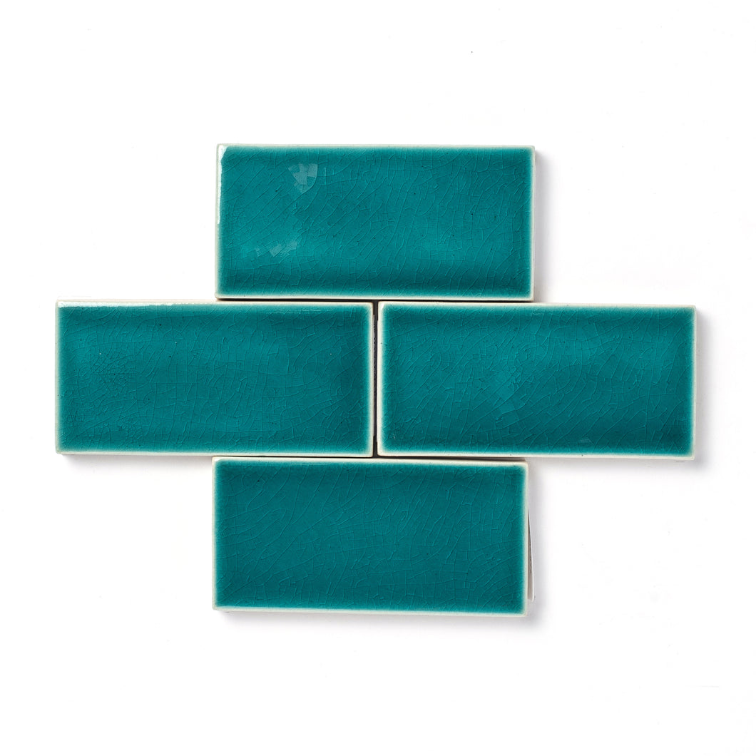 Hanauma Bay is a vibrant teal blue-green glaze that features a high-gloss surface texture with a uniquely formed crackle finish and a transparent break along tile edges and relief details.