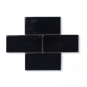 This sleek polished black glaze offers a slight variation in color, a high-gloss surface texture and an opaque break along tile edges and relief details.